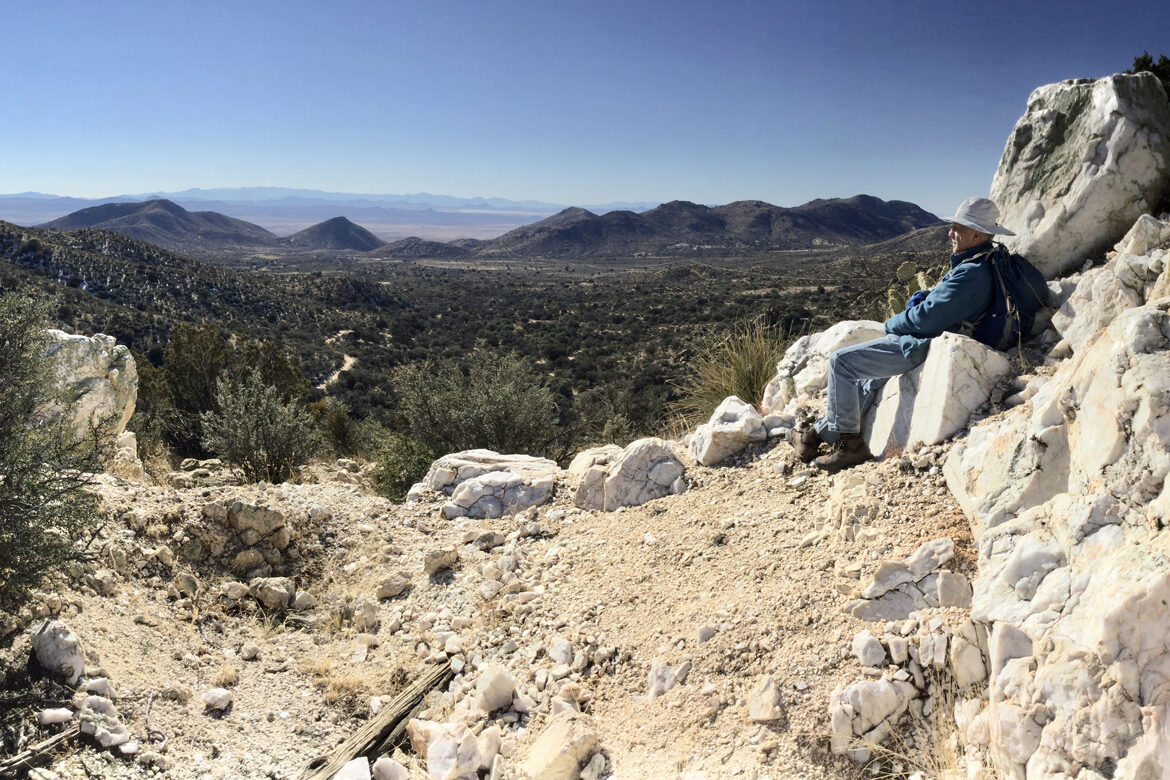 Hiker admiring the expansive view from the summit of Quartz Mountain Hiker admiring the expansive view from the summit of Quartz Mountain
