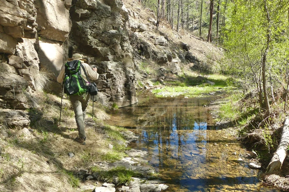 Hiker hiking next to a cliff in Meadow Creek Canyon Hiker hiking next to a cliff in Meadow Creek Canyon